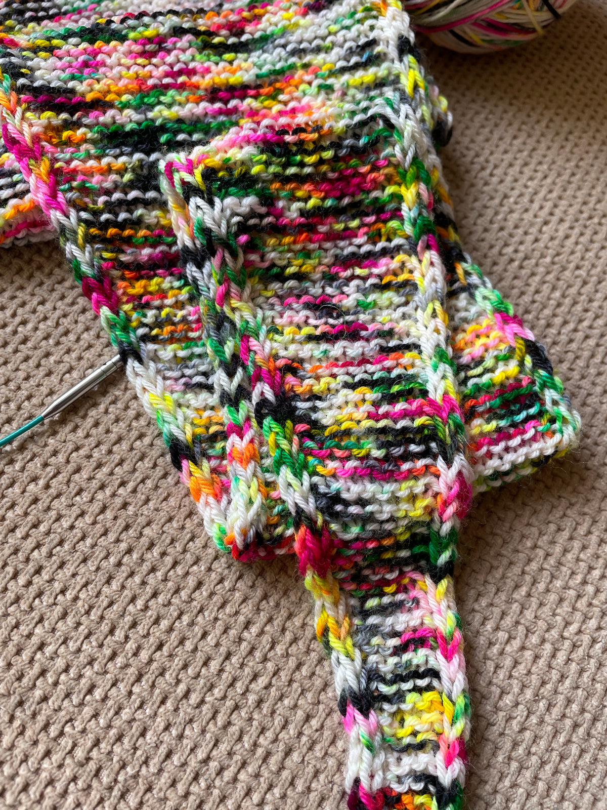 A knitted sample using 100g of Sock weight Punk Rocker. The knitting pattern is a large Sophie Scarf.